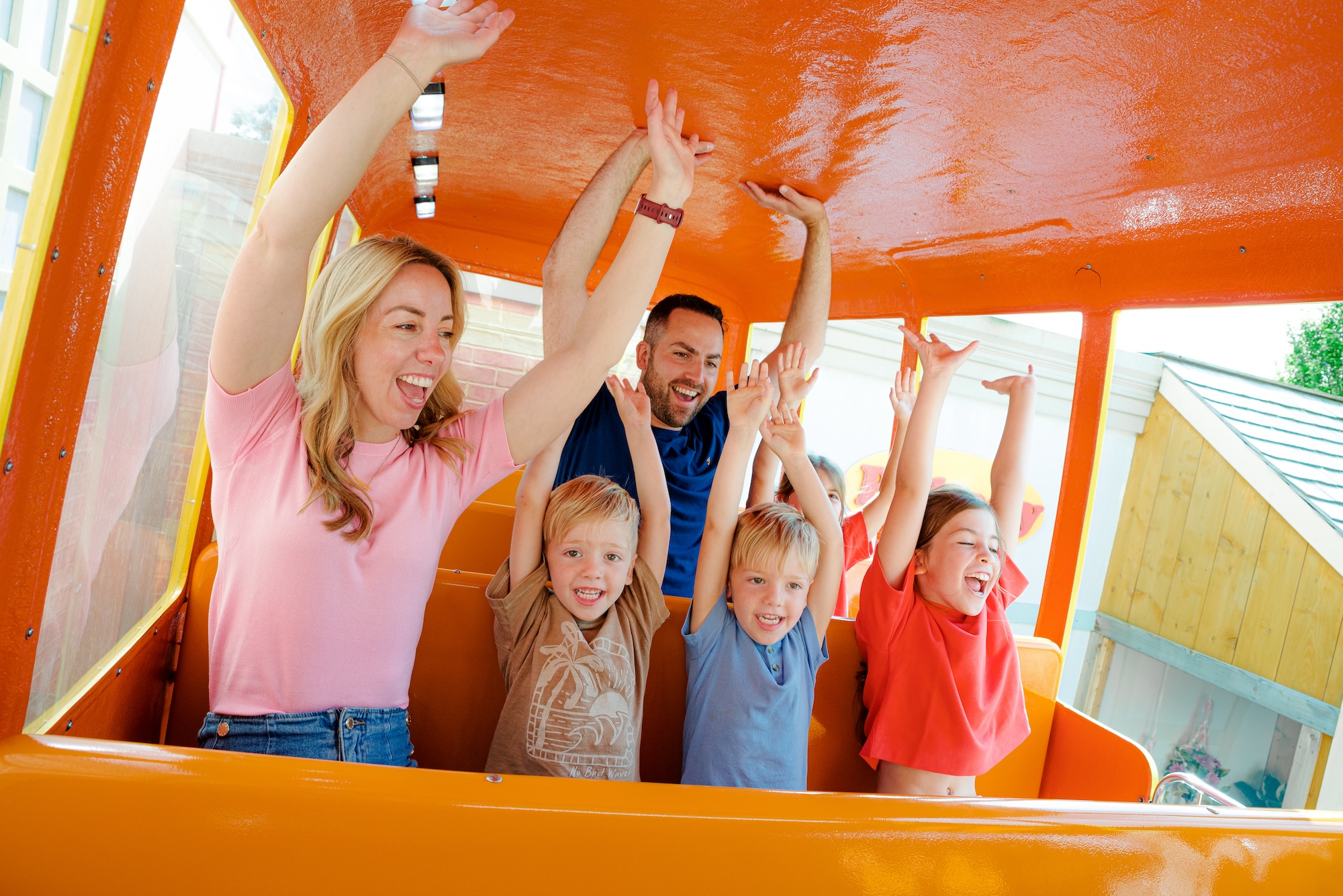 a family on crazy bus with their hands up